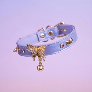 May include: A lavender leather choker with gold studs and a gold butterfly charm with a dangling ball.