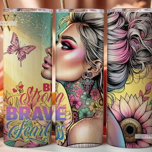 May include: A yellow and pink tumbler with a floral design and a woman's face with a tattoo. The text "Be Strong Brave Fearless" is on the tumbler.