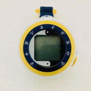 May include: A yellow and blue circular watch with a digital display and a black and white yin yang symbol. The watch face has Chinese characters around the edge.