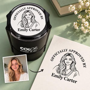 Peut inclure: Un tampon encreur noir Colop Printer R 40 avec un motif circulaire portant le texte "OFFICIALLY APPROVED BY" et le nom "Emily Carter" ainsi qu'un portrait au trait d'une personne, avec une empreinte d'encre assortie sur papier.