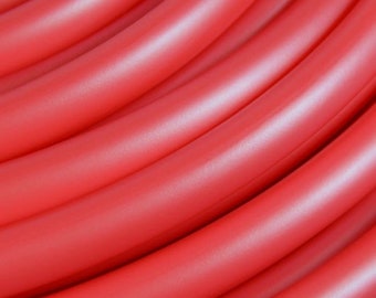 May include: Close-up of a stack of bright red rubber tubing. The tubing is smooth and shiny, with a slight sheen.