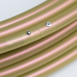 May include: Close-up of a hoop with a light green and pink iridescent finish. The hoop is made of plastic and has two silver metal accents.