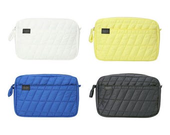 May include: Four quilted makeup bags in different colors: white, yellow, blue, and black. Each bag has a zipper closure and a small pocket on the front.