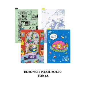 Op de afbeelding: Vier kleurrijke Hobonichi potloodborden voor A6-notitieboekjes. Ontwerpen omvatten een manga-stijl illustratie, een blauw-witte bergscène, een kamer met een kat en een blauw bord met de tekst "Tamagotchi".