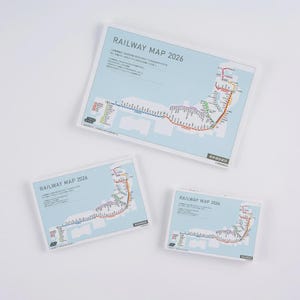 May include: Three railway maps titled "RAILWAY MAP 2026" are displayed on a white surface. The maps feature colorful railway lines over a light blue background. The maps are in different sizes.