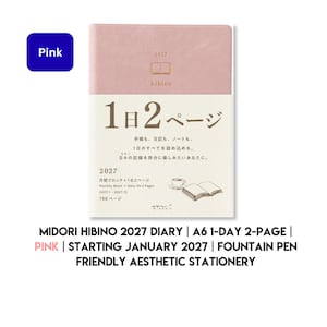 Könnte beinhalten: Ein rosafarbener Hibino 2027 Terminkalender mit einer cremefarbenen Papierbanderole. Der Einband zeigt ein kleines Buchsymbol und den Text 2027 hibino. Die Banderole enthält den Text 1日2ページ, 2027, Monthly Block + Daily On 2 Pages, 2027.1-2027.12, 768 ページ sowie eine kleine Illustration einer Tasse und eines offenen Buches.