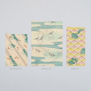 May include: Three rectangular cards with Japanese-style illustrations. One card features diagonal stripes with leaves and seeds. Another depicts birds near a river. The third card has a repeating pattern of yellow and pink shapes with green leaves.