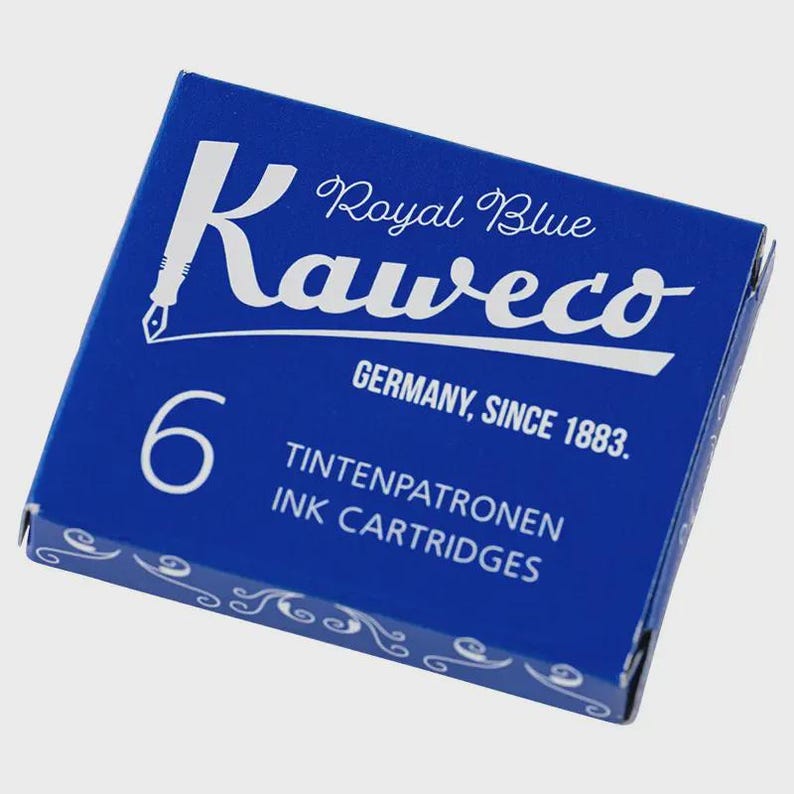 Puede incluir: Una caja azul de cartuchos de tinta Kaweco Royal Blue. La caja presenta el logotipo de Kaweco en blanco, el texto "Royal Blue", "Germany, Since 1883" y el n&uacute;mero "6". La caja tambi&eacute;n dice "INK CARTRIDGES".