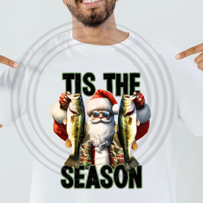 May include: A white t-shirt with a Christmas-themed design featuring Santa Claus holding two fish and the text "Tis the Season".