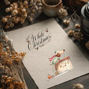 May include: A textured off-white paper sheet featuring the black cursive text White Christmas and a watercolor illustration of a dachshund wearing a green hat and red scarf, perched on a chimney decorated with colorful string lights and gifts.
