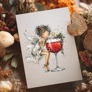 Peut inclure: Une carte de v&oelig;ux pr&eacute;sentant une illustration fantaisiste d'une f&eacute;e aux cheveux fonc&eacute;s et aux ailes blanches, v&ecirc;tue d'une robe scintillante, appuy&eacute;e contre un grand verre &agrave; vin rempli de liquide rouge, orn&eacute; de houx et d'une petite &eacute;toile jaune.