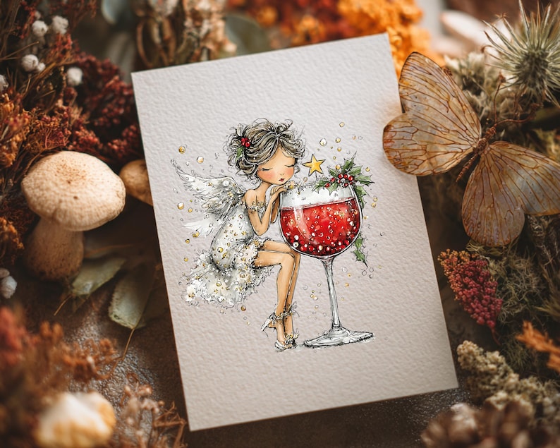 Peut inclure: Une carte de v&oelig;ux pr&eacute;sentant une illustration fantaisiste d'une f&eacute;e aux cheveux fonc&eacute;s et aux ailes blanches, v&ecirc;tue d'une robe scintillante, appuy&eacute;e contre un grand verre &agrave; vin rempli de liquide rouge, orn&eacute; de houx et d'une petite &eacute;toile jaune.