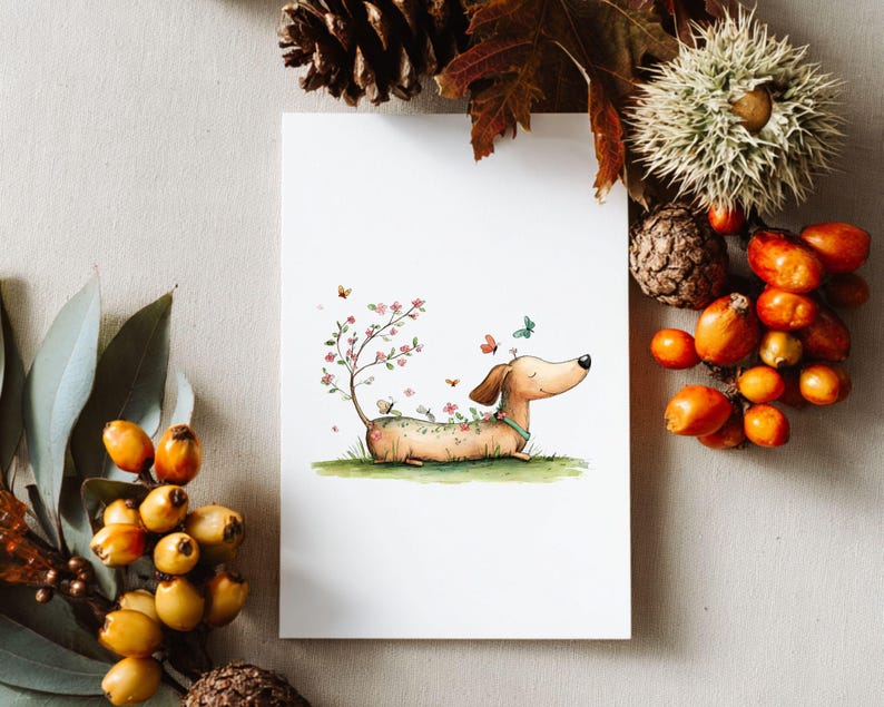 May include: A watercolour illustration of a dachshund dog lying on grass, decorated with flowers and butterflies. A small tree with pink blossoms grows from its back. The dog has a light brown coat and a blue collar. The artwork is on a white card.