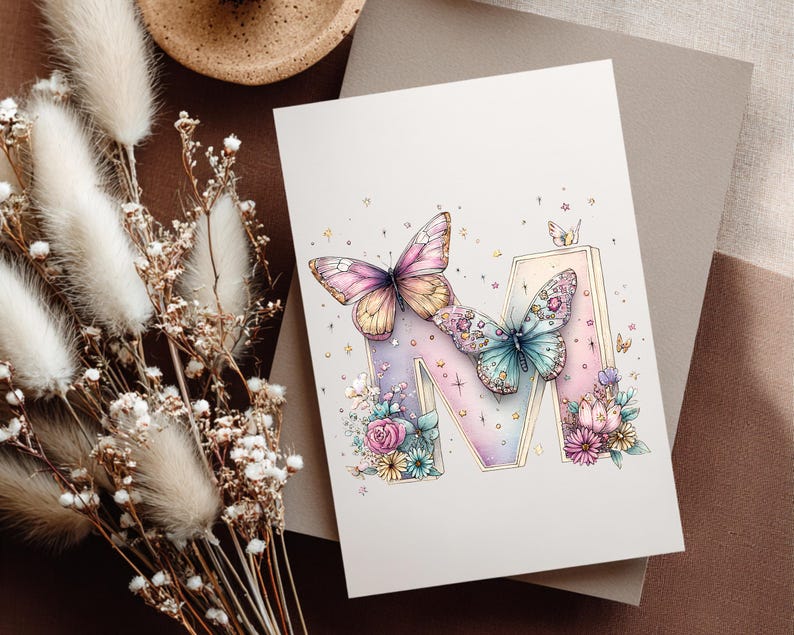 May include: A greeting card featuring a watercolor illustration of the letter "M" decorated with butterflies and flowers. The butterflies have pink, yellow, and blue wings. The flowers are in shades of pink, blue, and yellow.