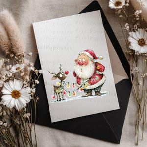 K&ouml;nnte beinhalten: Eine Weihnachtskarte mit dem Weihnachtsmann und einem Rentier, das sich in bunten Lichtern verfangen hat. Der Weihnachtsmann in seinem roten Anzug und Hut sieht &uuml;berrascht aus. Die Karte liegt auf einem schwarzen Umschlag, umgeben von Trockenblumen.