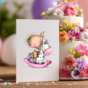 May include: A greeting card featuring a whimsical illustration of a child riding a rocking horse with a giraffe. The rocking horse is white with pink accents. A multi-tiered cake decorated with colorful flowers is in the background.