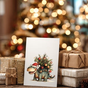 May include: A Christmas card featuring a cartoon dinosaur wearing a Santa hat and carrying a decorated Christmas tree on its back. The card is set against a backdrop of wrapped gifts and a blurred Christmas tree with warm lights.