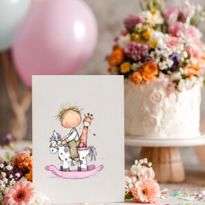 May include: A greeting card featuring a watercolor illustration of a child riding a rocking horse with a giraffe. The rocking horse is white with black spots and a pink base. The card is set in front of a cake and balloons.