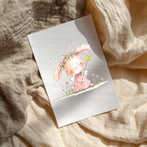 Op de afbeelding: Een rechthoekige print met een aquarelillustratie van een lichtroze konijn met een bloemenkrans op die een gele sterrenstaf vasthoudt. Het konijn heeft lange oren, kleine vleugels en staat op een ondergrond met kleine roze bloemetjes.