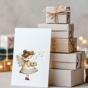 May include: A greeting card featuring a whimsical illustration of an angel holding a music box, with musical notes floating around her. The card is set against a backdrop of stacked, wrapped gift boxes tied with twine, suggesting a festive occasion.