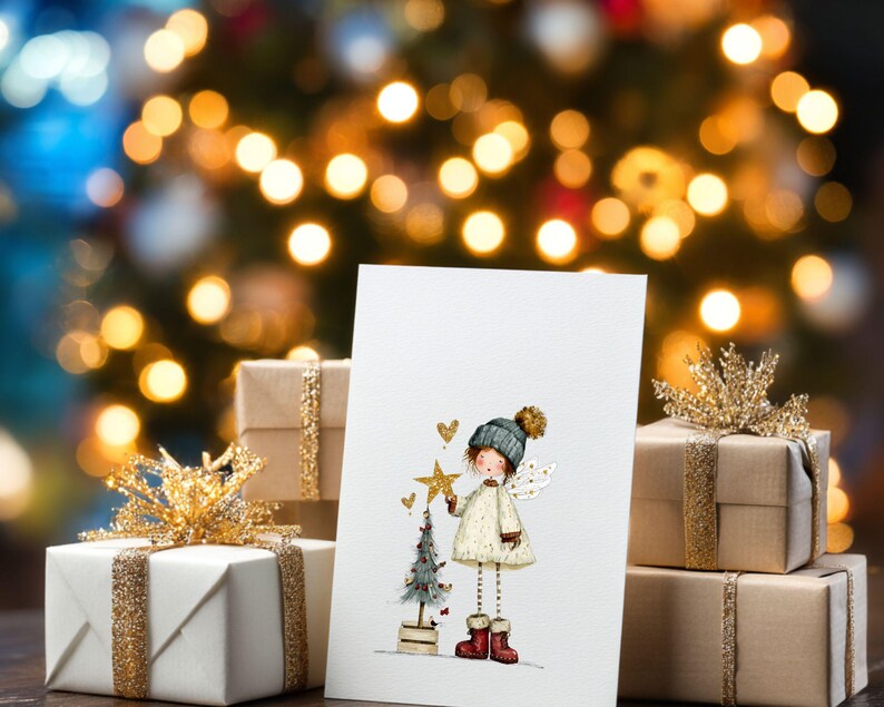 May include: A Christmas card featuring an illustration of a girl angel holding a star, with a small Christmas tree. The card is propped up in front of wrapped gifts with gold ribbon and a blurred Christmas tree background.