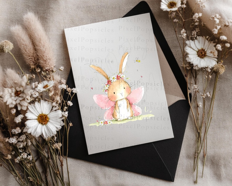 Op de afbeelding: Een rechthoekige wenskaart met een aquarelillustratie van een lichtbruin konijntje met roze fee&euml;nvleugels en een bloemenkrans. Het konijntje staat op een stukje gras met een kleine bij en kleine rode hartjes in de buurt.