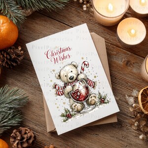 Peut inclure: Une carte de v&oelig;ux blanche avec une illustration dessin&eacute;e &agrave; la main d'un ours en peluche brun clair portant une &eacute;charpe ray&eacute;e rouge et blanche, tenant un verre de vin rouge avec un sucre d'orge, et le texte rouge Christmas Wishes imprim&eacute;.