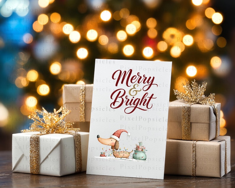 May include: A white greeting card with the red text Merry & Bright, featuring a cartoon dachshund wearing a Santa hat and tangled in Christmas lights, surrounded by gift boxes wrapped in brown paper with gold glitter ribbons.