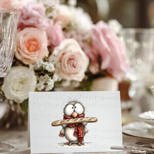 May include: A greeting card featuring a whimsical owl illustration. The owl, with large eyes and a red scarf, is holding a baguette. The background includes a floral arrangement and a crystal wine glass.