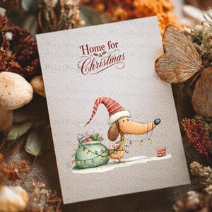 May include: A rectangular greeting card featuring the text Home for Christmas in red script. Below, a tan dachshund wears a red and white striped Santa hat, tangled in colorful string lights, standing next to a green sack of gifts.