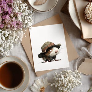 May include: A watercolor illustration of a small, furry creature wearing a hat, set on a white card. The image is surrounded by flowers, a cup of tea, and a small pastry. The color palette includes browns, whites, and greens.