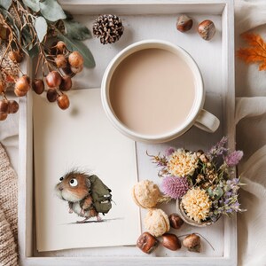 May include: A cozy autumn-themed still life. A mug of coffee sits beside a drawing of a small animal with a backpack. The scene includes fall foliage, nuts, and a small bouquet of flowers, all arranged on a white tray.