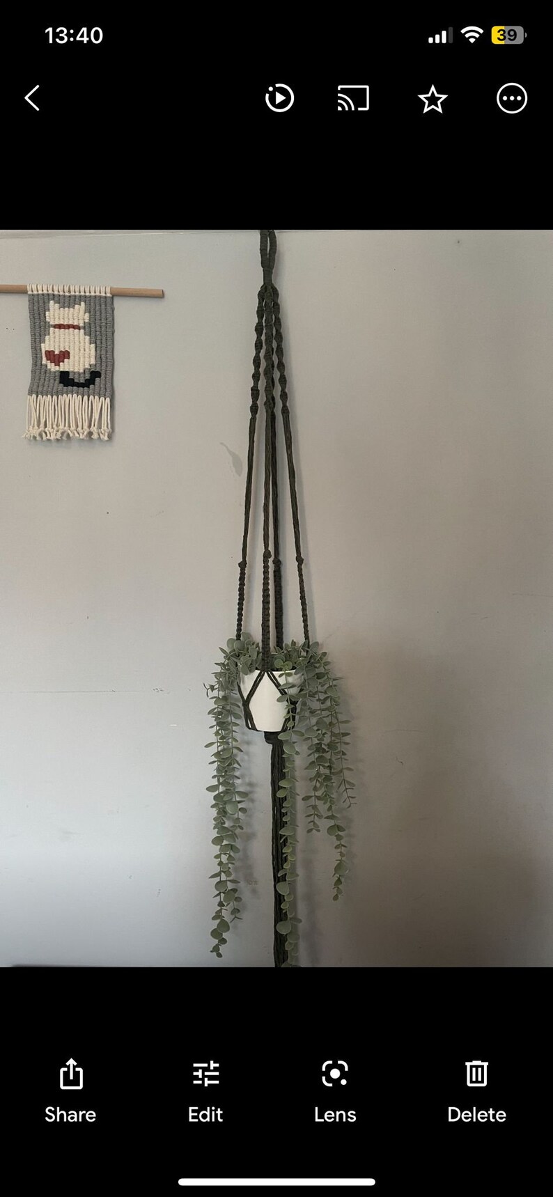 Peut inclure: Un porte-plante en macram&eacute; vert fonc&eacute; avec un pot en c&eacute;ramique blanc et une plante verte retombante. Le porte-plante est suspendu &agrave; un mur gris clair.