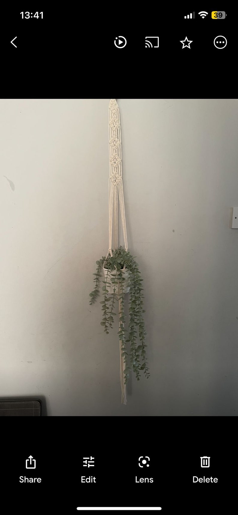 Peut inclure: Un porte-plante en macram&eacute; blanc avec une plante verte suspendue. La plante est dans un pot blanc.