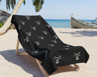 Mycket piratliknande strandhandduk med Jolly Roger-piratdödskalle och korsbensdesign.