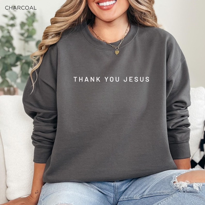 Peut inclure: Un sweat-shirt gris anthracite avec le texte "THANK YOU JESUS" imprim&eacute; en blanc sur le devant.