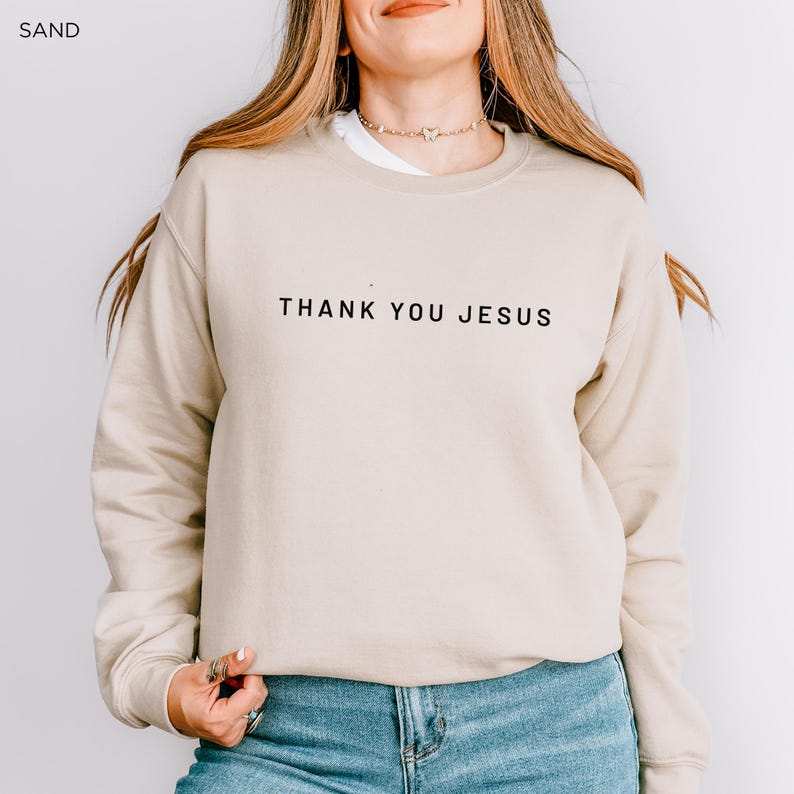 Peut inclure: Un sweat-shirt beige avec le texte "THANK YOU JESUS" imprim&eacute; en noir sur le devant.