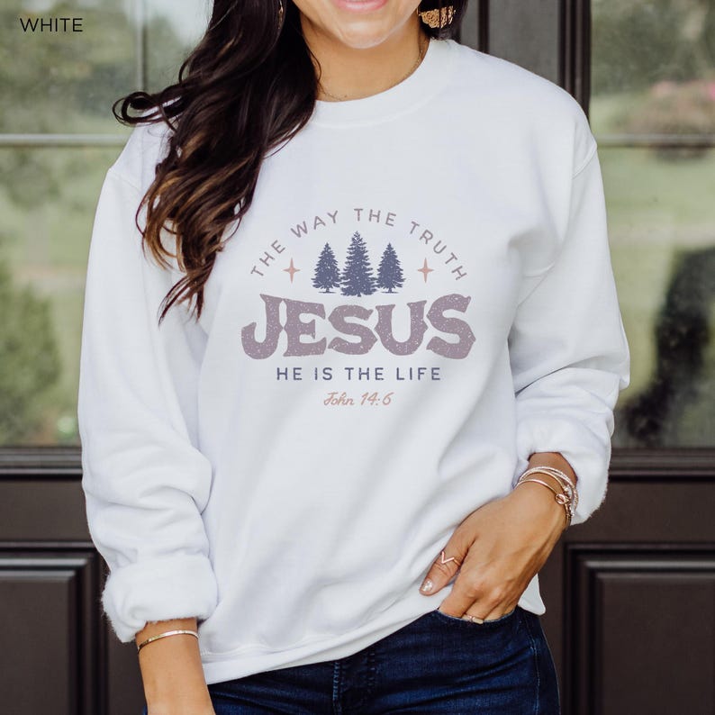 May include: White crew neck sweatshirt with the text "THE WAY THE TRUTH JESUS HE IS THE LIFE John 14:6" in a purple and gray design. The sweatshirt features a graphic of three trees above the word "JESUS".