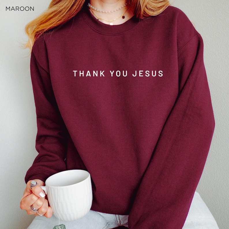 Peut inclure: Un sweat-shirt bordeaux avec le texte "THANK YOU JESUS" imprim&eacute; en blanc sur le devant.