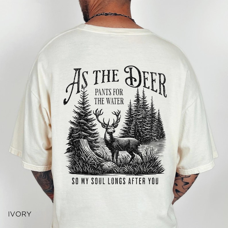 May include: Ivory t-shirt with a black graphic print of a deer in a forest with the text "As the Deer, Pants for the Water, So my soul longs after you".