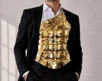 May include: A gold-colored, sculpted torso piece with defined abdominal muscles. The metallic chest plate is worn over a white shirt and black suit. The suit includes a black blazer and black pants. The person is standing in front of a plain background.