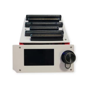 May include: A white electronic device with a black screen and a black knob. It has multiple black connectors on top and red accents. The device is designed for electronic components and has a modern, technical appearance.