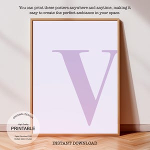 May include: Printable poster featuring the letter V in a light purple colour. The poster has a white background and is framed in a light wood frame. The text "ORIGINAL DESIGN", "High Quality", "PRINTABLE", "Digital Download PNG", and "Multiple Sizes Included" is visible at the bottom left corner of the poster. The text "INSTANT DOWNLOAD" is visible at the bottom centre of the poster.