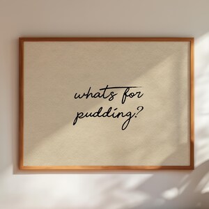 Może przedstawiać: Oprawiony wydruk z napisem "whats for pudding?" w stylu ręcznym. Wydruk ma jasnobeżowe tło i drewnianą ramę. Obraz jest dobrze oświetlony, z cieniem po prawej stronie.