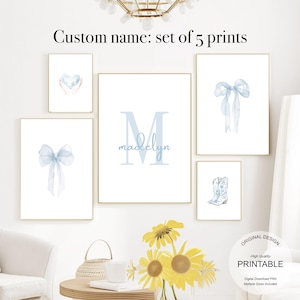 Pode incluir: Conjunto de cinco impressões de arte de parede imprimíveis com um laço azul de aquarela, um coração com mãos, um monograma com o nome "madelyn", um laço azul de aquarela e um par de botas de cowboy.