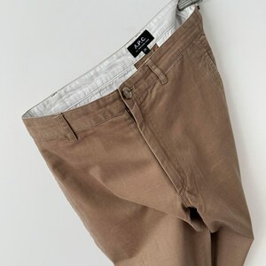 May include: A pair of brown cotton twill pants with a white label that says "A.P.C. Atelier de Production et de Cr&eacute;ation" and the number "29".