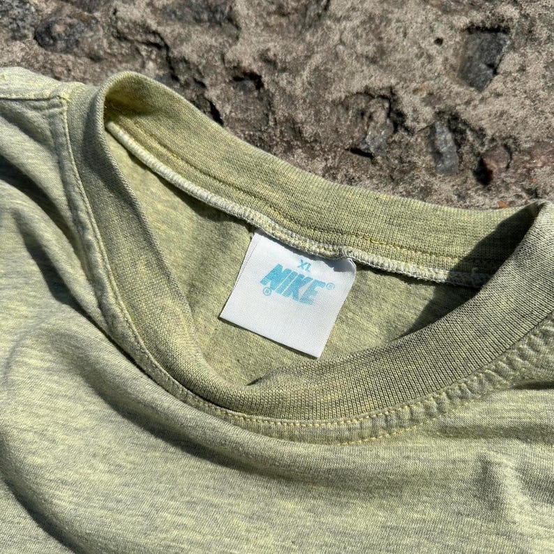 Peut inclure: Un t-shirt vert clair avec une &eacute;tiquette blanche indiquant "XL NIKE".
