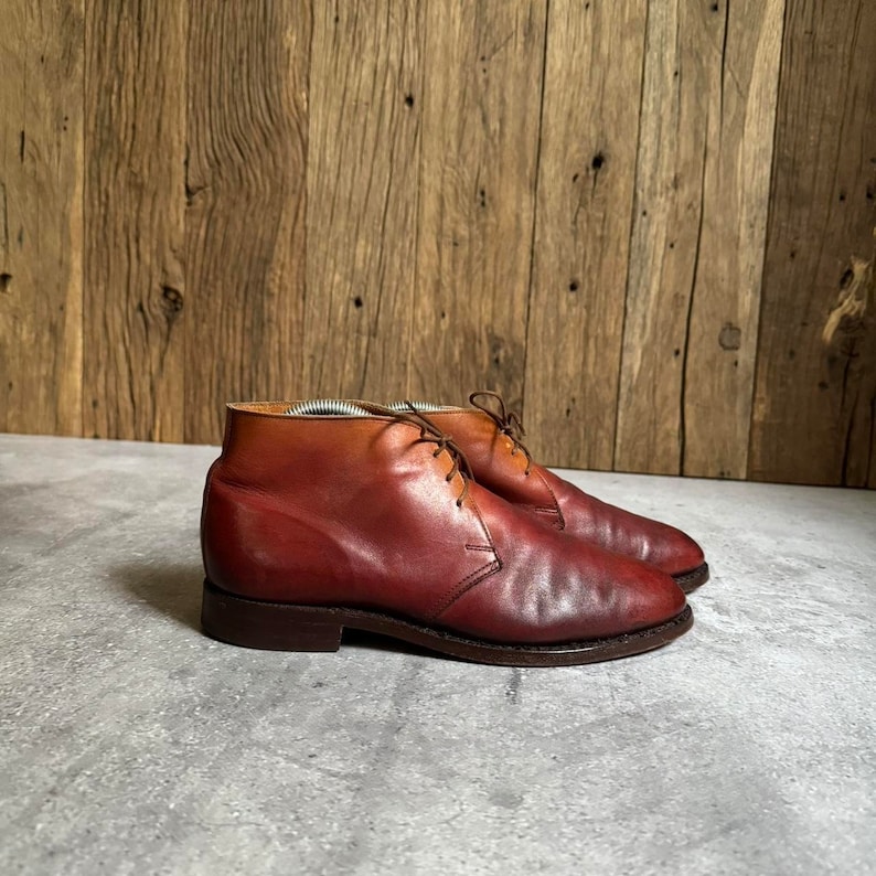 May include: A pair of brown leather ankle boots with laces. The boots have a rounded toe and a low heel.