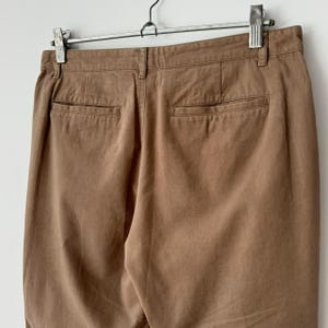 May include: A pair of brown twill pants with two back pockets.