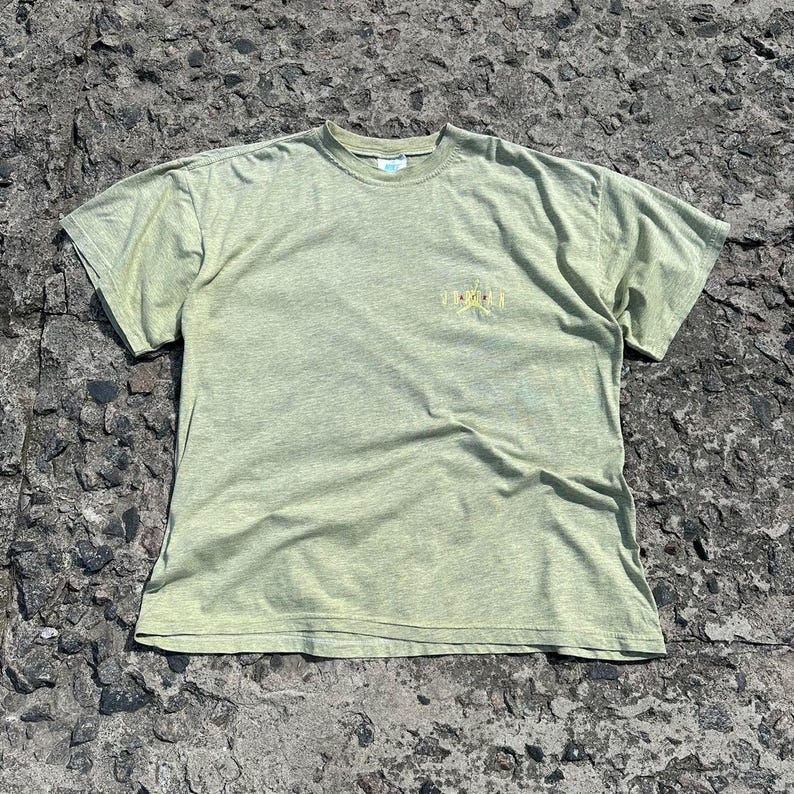 Peut inclure: Un t-shirt vert clair avec un imprim&eacute; graphique jaune d&eacute;lav&eacute; sur le devant. L'impression graphique dit "Summer"